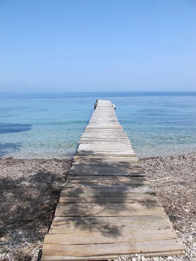 Boukari Beach in Corfu, featuring a pebbly shoreline with calm water conditions