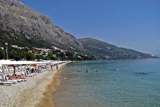Barbati Beach in Corfu, featuring a pebbly shoreline with calm water conditions