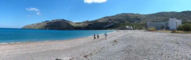 Vlycha Beach in Rhodes, featuring a sandy shoreline with moderate water conditions