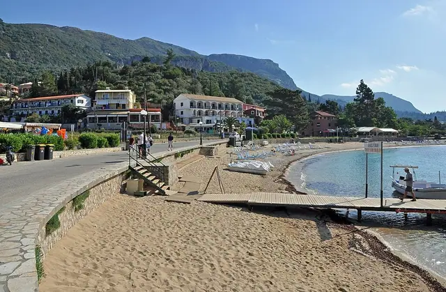 Agios Spyridon Palaiokastritsa Beach in Corfu, featuring a mixed shoreline with calm water conditions