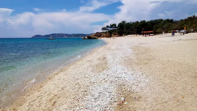 Pefkari beach in Thassos, featuring a pebbly shoreline with moderate water conditions
