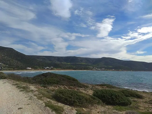 Agiassos Beach in Naxos, featuring a sandy shoreline with calm water conditions