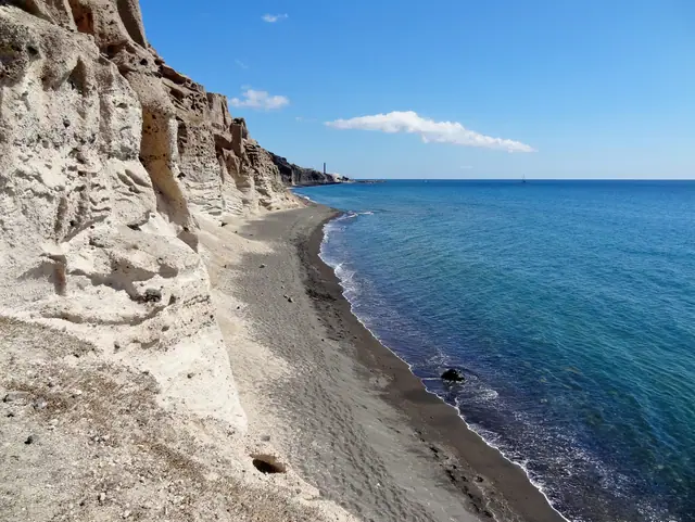 Vlychada Beach in Santorini, featuring a sandy shoreline with moderate water conditions
