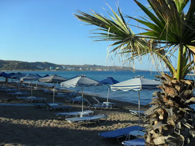 Faliraki B beach in Rhodes, featuring a sandy shoreline with moderate water conditions
