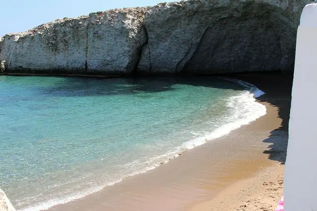 Mytakas Beach in Milos, featuring a sandy shoreline with calm water conditions