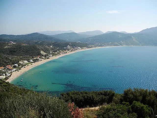 Agios Georgios Beach in Corfu, featuring a sandy shoreline with calm water conditions