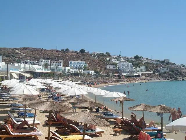 Platis Gialos beach in Mykonos, featuring a sandy shoreline with calm water conditions