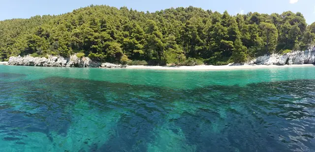 Kastani beach in Skopelos, featuring a sandy shoreline with moderate water conditions