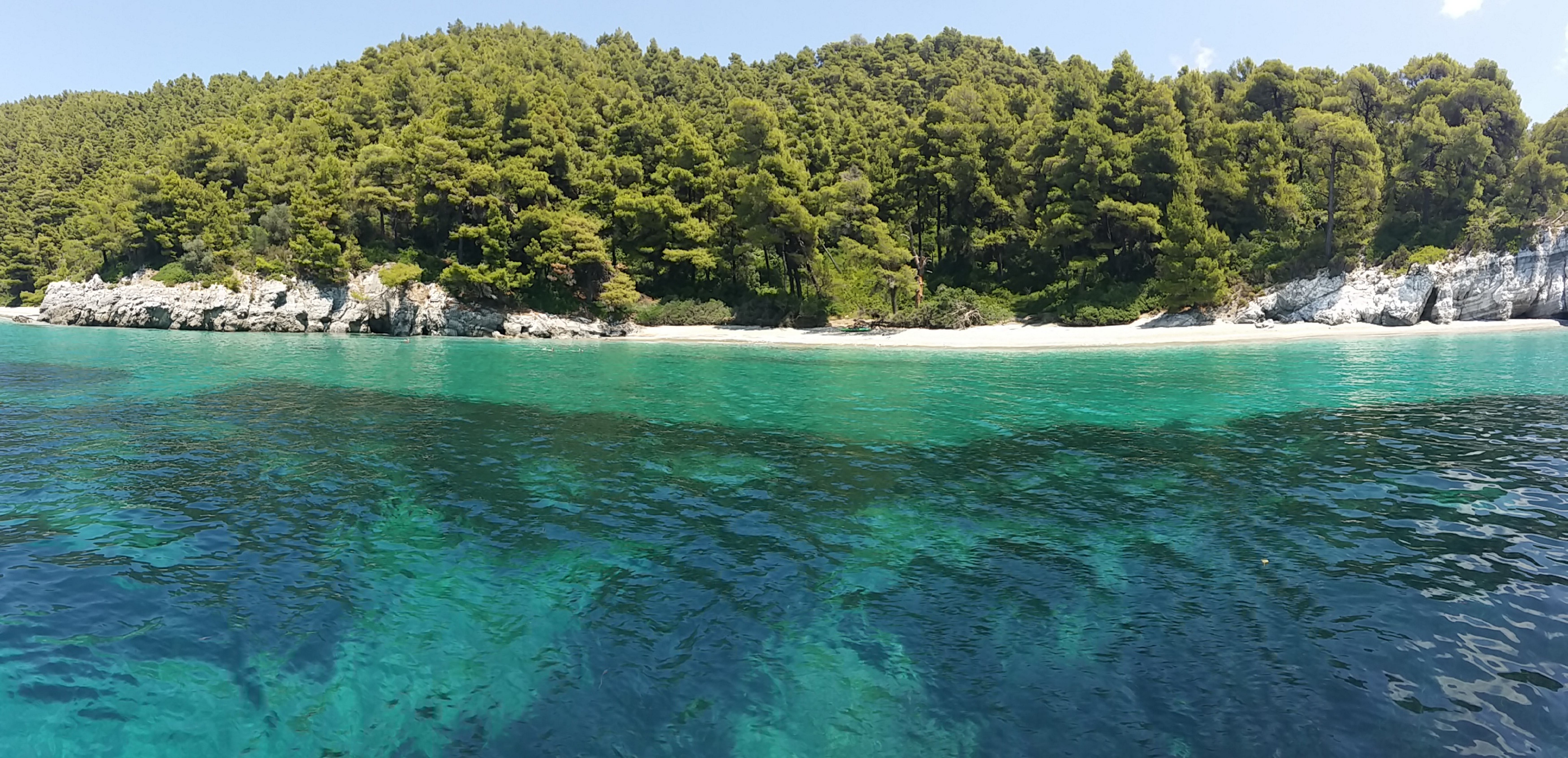 Kastani beach in Skopelos, featuring a sandy shoreline with moderate water conditions