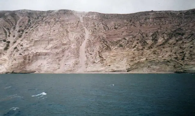 Gerakas Beach in Milos, featuring a sandy shoreline with calm water conditions