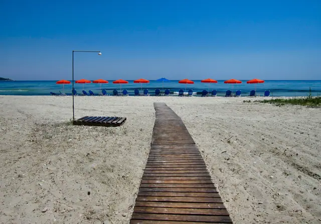 Golden Beach in Thassos, featuring a sandy shoreline with moderate water conditions, certified with Blue Flag status for environmental quality