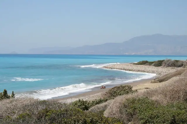 Kouloura Beach in Rhodes, featuring a pebbly shoreline with moderate water conditions