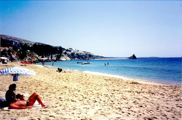 Platis Gialos Beach in Kefalonia, featuring a sandy shoreline with calm water conditions