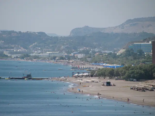 Paralia Faliraki beach in Rhodes, featuring a sandy shoreline with moderate water conditions, certified with Blue Flag status for environmental quality