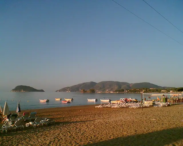 Laganas Beach in Zakynthos, featuring a sandy shoreline with calm water conditions