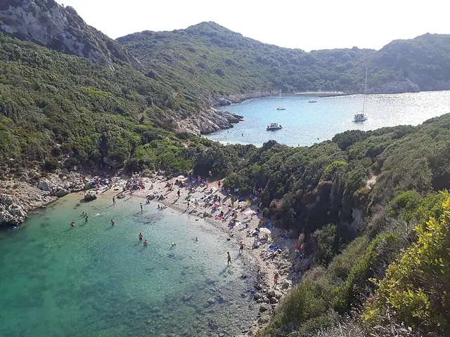 Porto Timoni beach in Corfu, featuring a pebbly shoreline with calm water conditions