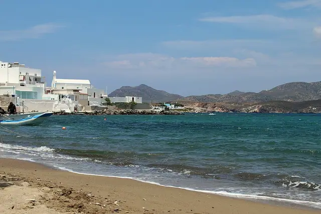 Pollonia Beach in Milos, featuring a sandy shoreline with calm water conditions