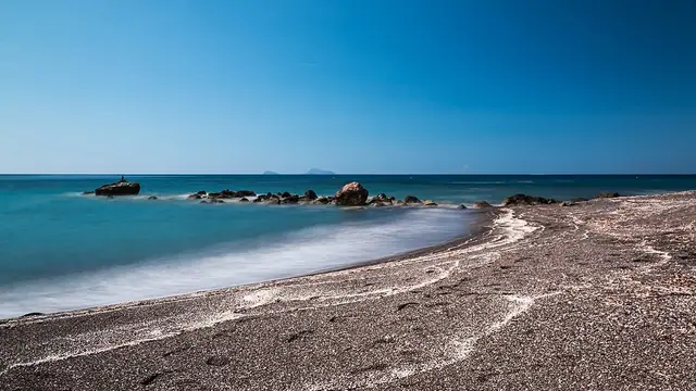 Exomitis Beach in Santorini, featuring a mixed shoreline with calm water conditions