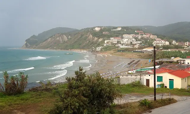 Agios Stefanos Beach in Corfu, featuring a sandy shoreline with calm water conditions