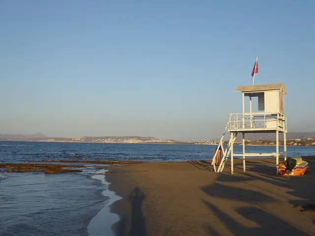 Agia Marina Beach in Crete, featuring a sandy shoreline with calm water conditions