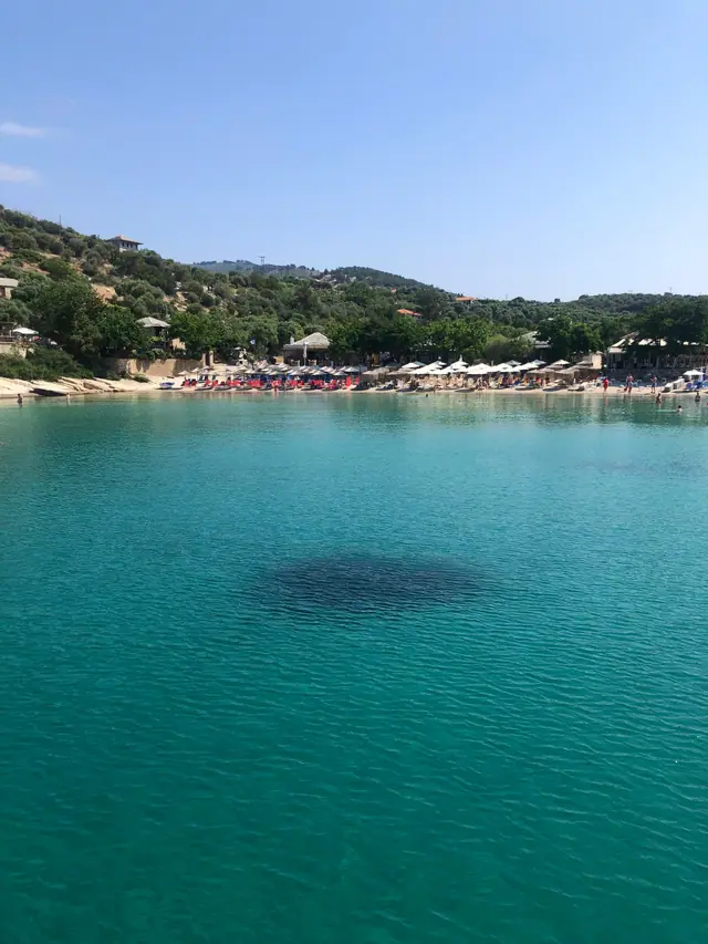 Alyki beach in Thassos, featuring a sandy shoreline with moderate water conditions