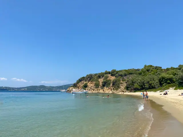 Tsougkrias Beach in Skiathos, featuring a sandy shoreline with moderate water conditions