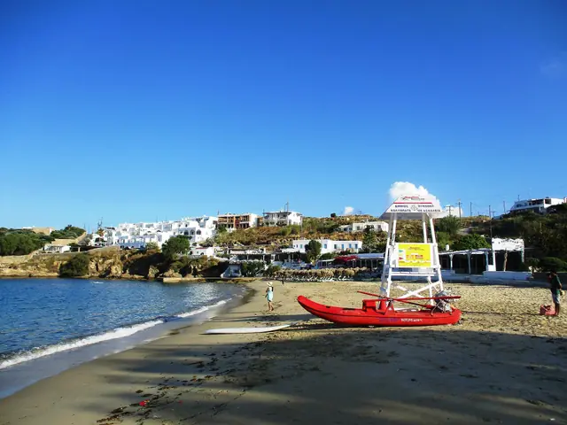 Agios Stefanos beach in Mykonos, featuring a sandy shoreline with calm water conditions