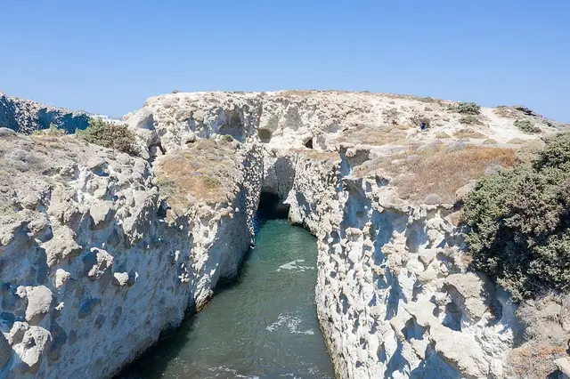 Papafragas Beach in Milos, featuring a sandy shoreline with wavy water conditions