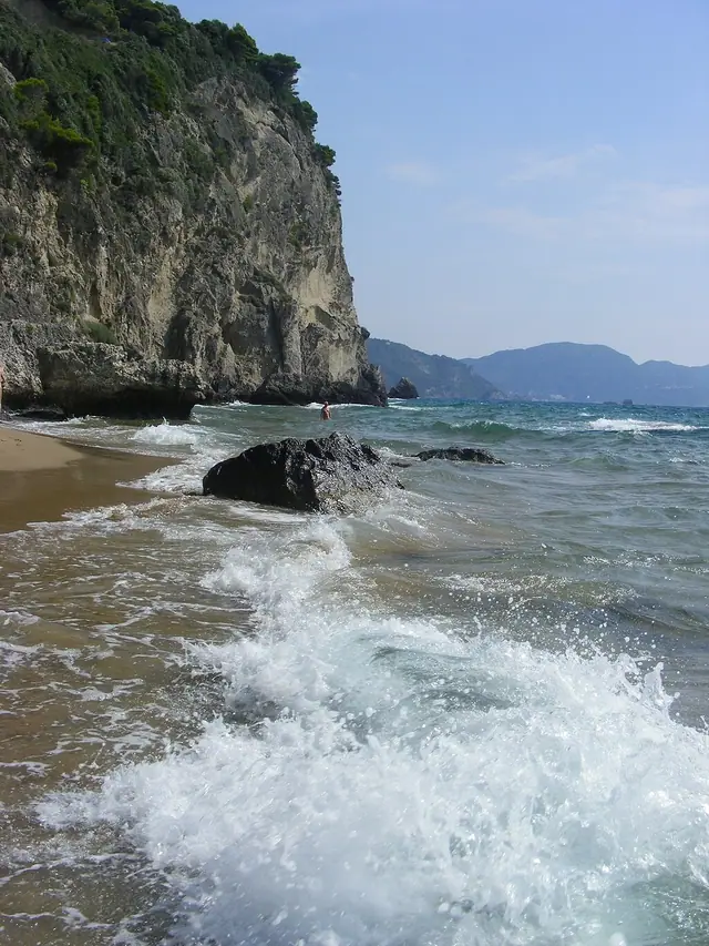Myrtiotissa Beach in Corfu, featuring a sandy shoreline with calm water conditions