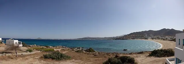 Orkos Beach in Naxos, featuring a sandy shoreline with wavy water conditions